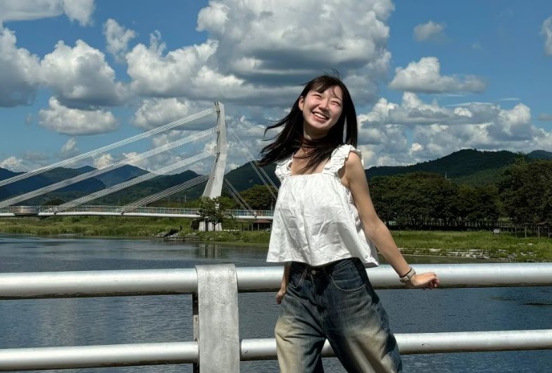 Juha Park outdoors by a riverside bridge